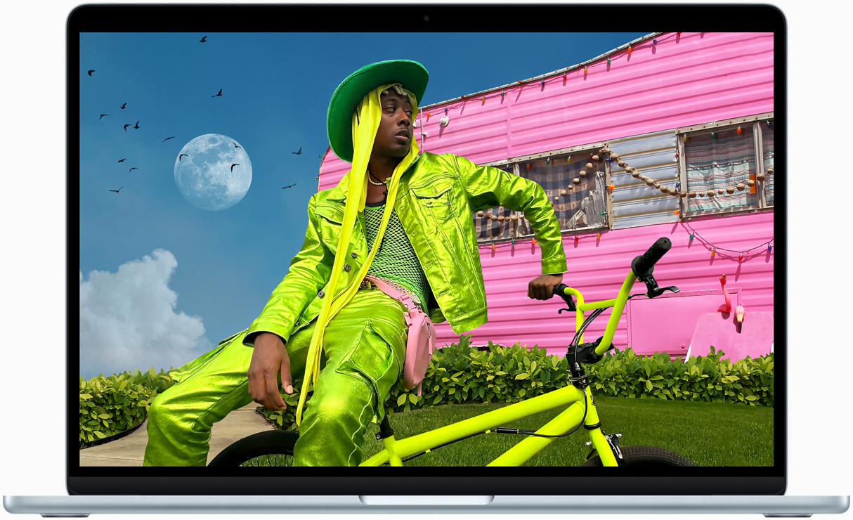 Ecranul MacBook Air afișează o poză a unei persoane în ținută colorată, demonstrând gama cromatică și rezoluția ecranului Liquid Retina